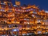 Des bâtiments traditionnels à étages illuminés la nuit à Chongqing