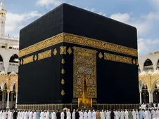 La Kaaba vue de près, drapée de sa kiswa noire brodée d’or, entourée de pèlerins